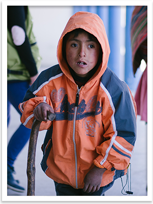A boy in Peru, using a walking stick because of muscular dystrophy.