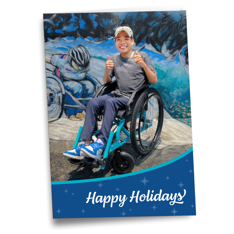 A greeting card saying Happy Holidays, featuring a young Thai man in a wheelchair, smiling.