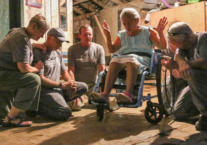 A team from Idaho prays for a wheelchair recipient in NIcaragua.